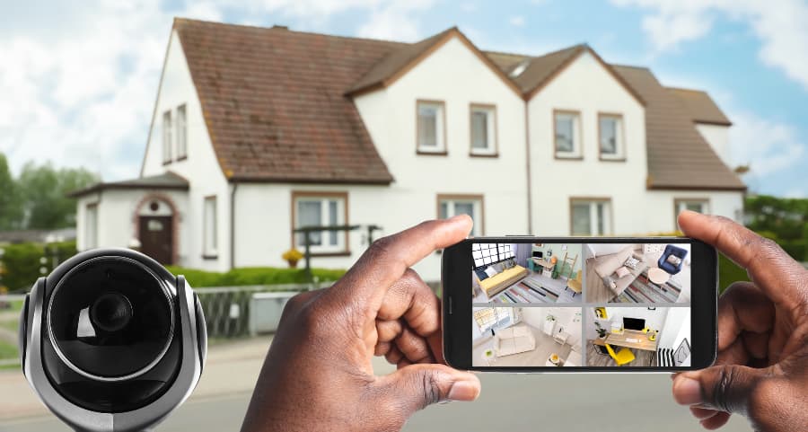 Man holding mobile device and checking streams from video cameras